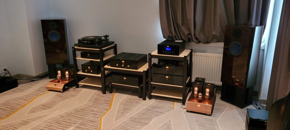 HiFi Delux, München 2025 Raum mit High-end Audiogeräte, Plattenspieler, CD-Spieler, Röhrenverstärker mit schwarze Fronten, schöne Lautsprechern mit blaue Membranen.